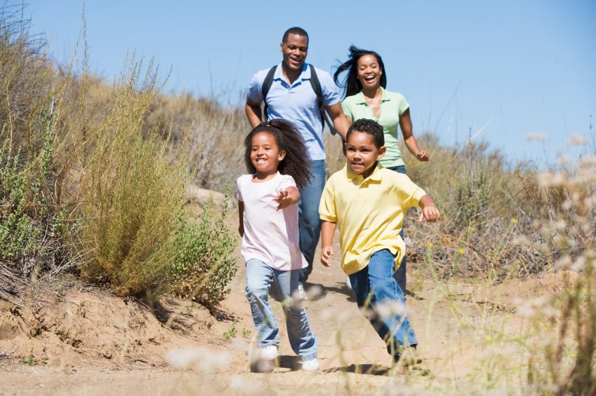 Family running on path smiling